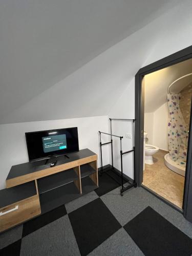 a room with a television on a table and a mirror at Vila Alemary in Năvodari