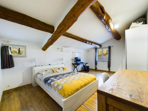 ein Schlafzimmer mit einem Bett in einem Zimmer mit Holzboden in der Unterkunft Villa Crousadou, 10 personnes avec piscine à Saint-Rémy-de-Provence in Saint-Rémy-de-Provence
