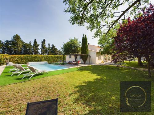 une cour avec des chaises longues et une piscine dans l'établissement Villa Crousadou, 10 personnes avec piscine à Saint-Rémy-de-Provence, à Saint-Rémy-de-Provence