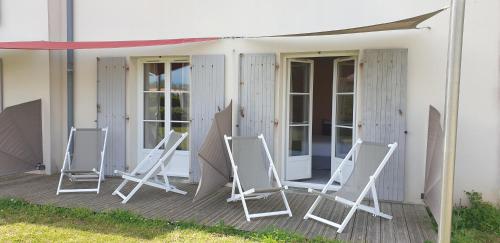 three folding chairs sitting on a porch of a house at Thalacap Île de Ré - Thalasso & Spa in Ars-en-Ré