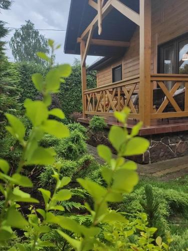 a log cabin with a porch and a deck at Chmielna Chatka in Majdan Łuczycki