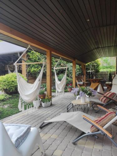 a patio with hammocks and chairs on a deck at Chmielna Chatka in Majdan Łuczycki