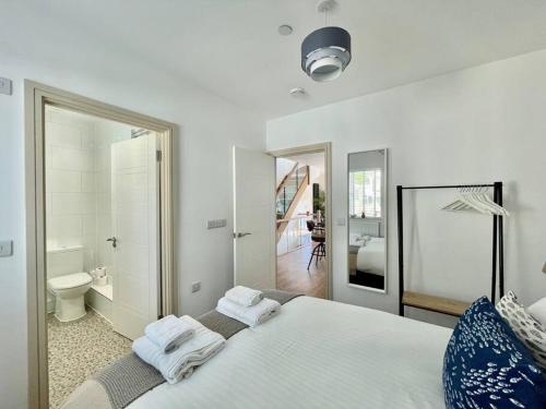 1 dormitorio con 1 cama blanca grande y baño en 3 The Boatyard - Luxurious waterside 4 bed townhouse, lift, parking en Kingsbridge