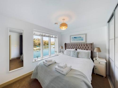 a bedroom with a large bed with towels on it at 3 The Boatyard - Luxurious waterside 4 bed townhouse, lift, parking in Kingsbridge