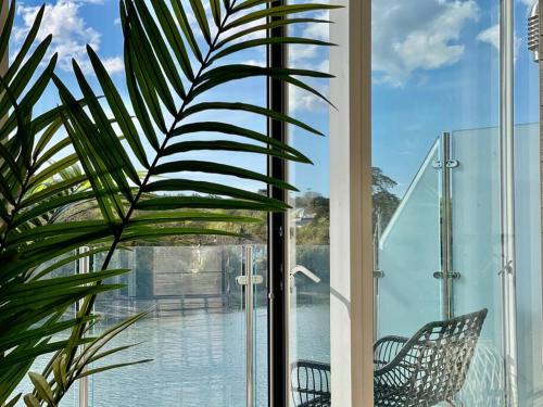 a window with two chairs and a view of the water at 3 The Boatyard - Luxurious waterside 4 bed townhouse, lift, parking in Kingsbridge
