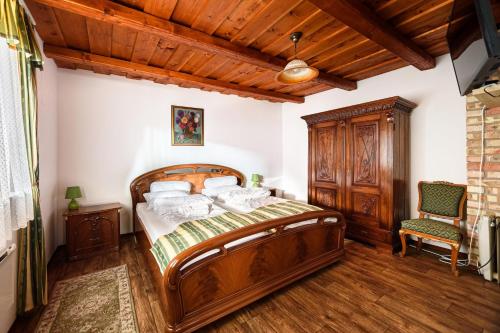 Bér的住宿－Malom Udvar Panzió és Étterem，一间卧室配有一张木床和一把椅子