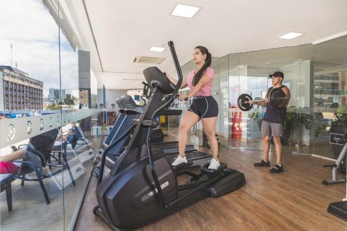 a man and a woman on a treadmill in a gym at Golden Tulip Porto Vitória in Vitória