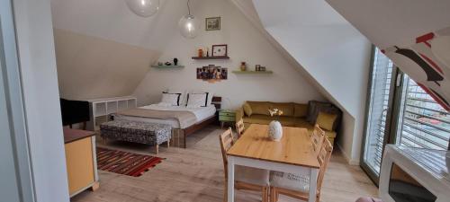 a attic room with a bed and a table at Vánkoska Apartman Tihany in Tihany