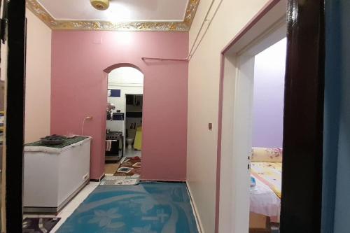a room with a pink wall and a blue floor at Real Egypt is waiting for you in Sinnūris