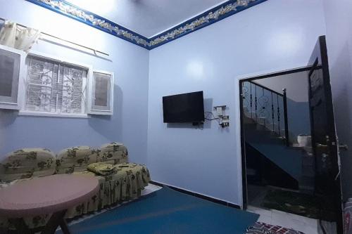 a room with a table and chairs and a tv at Real Egypt is waiting for you in Sinnūris