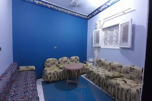 a room with blue walls and chairs and a table at Real Egypt is waiting for you in Sinnūris