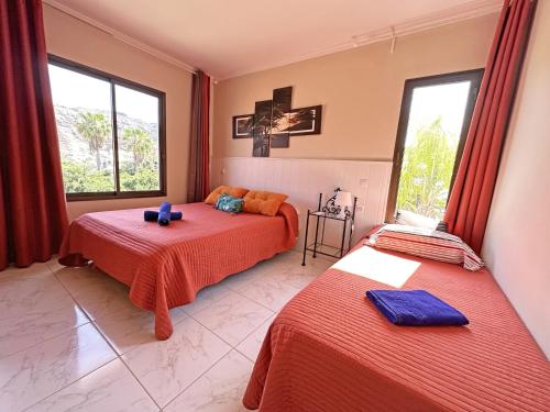 1 dormitorio con 2 camas con sábanas rojas en Luxury Villa Lucia, en La Playa de Tauro