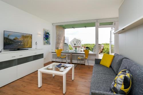 a living room with a couch and a tv at Strandsonne in List