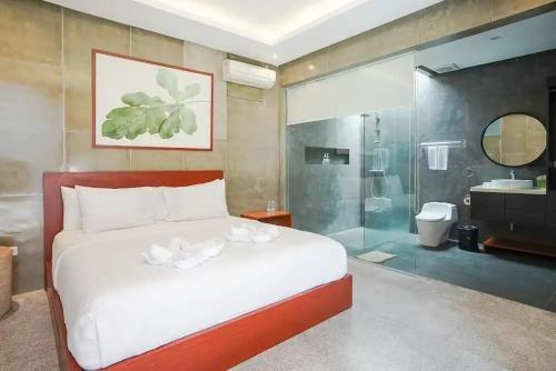 a bedroom with a bed and a bathroom with a shower at Aqilah Villa Bali in Legian