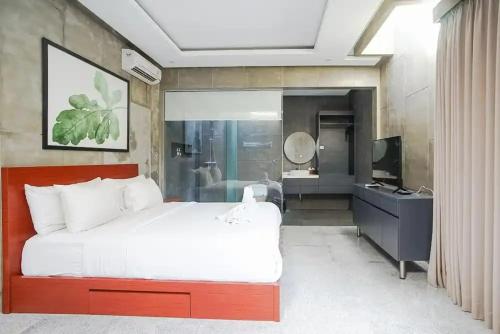 a bedroom with a large bed and a bathroom at Aqilah Villa Bali in Legian