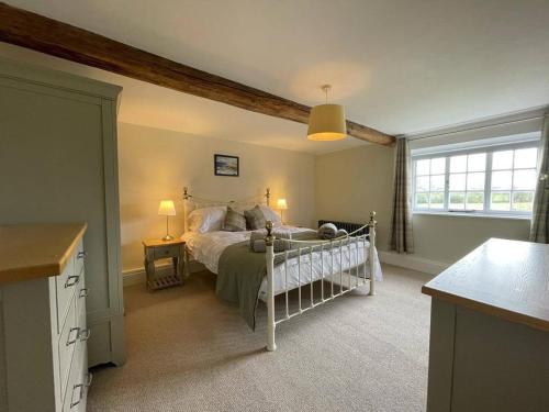 Un dormitorio con una cama blanca y una ventana. en Woodpecker Cottage, en West Bretton