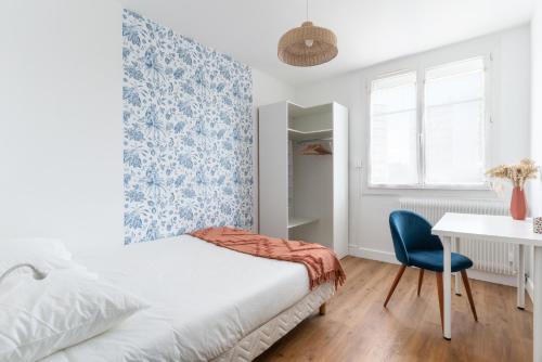 南特的住宿－Joli Appartement avec Garage sur l'Île de Nantes，一间卧室配有一张床、一张桌子和一把椅子