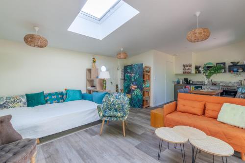 ein Wohnzimmer mit Sofa und Tisch in der Unterkunft La Halte des Miquelots - Appt avec jardin in Vains