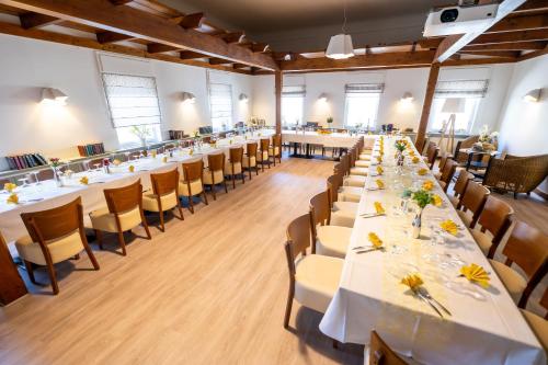 a large room with long tables and chairs at Kummerower Hof in Neuzelle