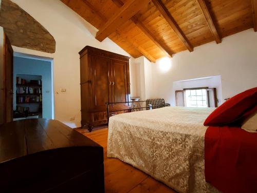 Il Monte BnB في Tazzola: غرفة نوم بسرير كبير وخزانة خشبية