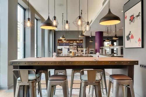 a bar with stools around a large wooden table at Premier Inn Berlin Alexanderplatz in Berlin