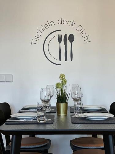 a black table with glasses and a sign that reads garden desk dip at Goethe Palais Suite Zauberlehrling 4P l Lift l Parkplatz I Zentrum I Helios in Aue