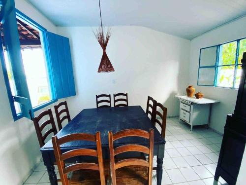 a dining room with a blue table and chairs at 4 quartos ao lado da praia do Patacho in Pôrto de Pedras