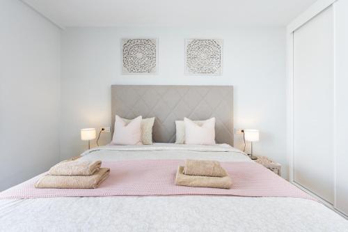 una camera da letto con un grande letto con due asciugamani di Home2Book Stylish & Relax Attic La Tejita, Pool a La Tejita