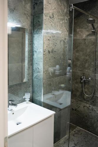 a bathroom with a glass shower and a sink at Hotel Luris in Golem