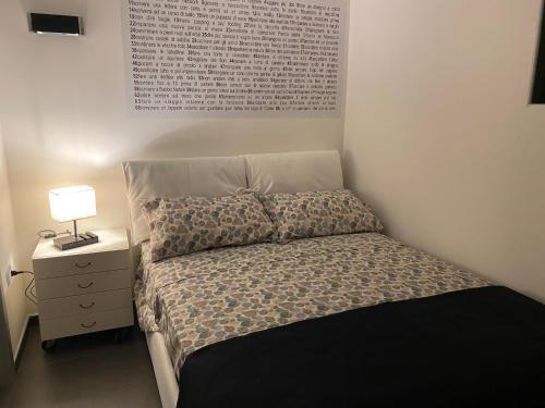 ein Schlafzimmer mit einem Bett und einer Lampe auf einem Nachttisch in der Unterkunft Attico Tra Cielo e Mare in Margherita di Savoia