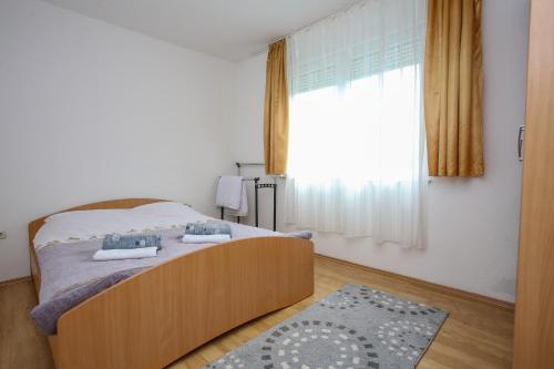 um quarto com uma cama e uma grande janela em Apartment Hercegovina em Mostar