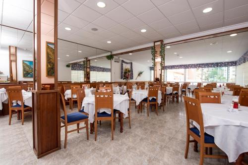 a dining room with white tables and chairs at Hotel Internacional in Calella