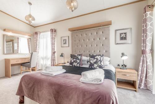 1 dormitorio con 1 cama grande y escritorio en Stewarts Resort Lodge 52 en St Andrews