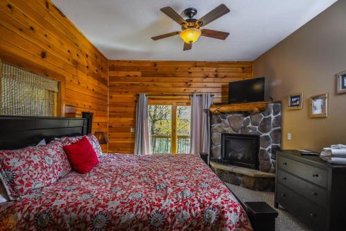 1 dormitorio con 1 cama y chimenea de piedra en Cozy Bear Chalet, en McHenry