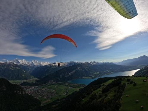 a person is flying a parachute over a lake at Snowflake in Leissigen