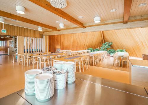 una sala da pranzo con piatti bianchi, tavoli e sedie di Honkiniemi a Ähtäri