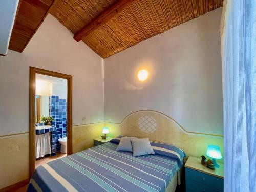 a bedroom with a bed and a bathroom with a window at Domo s'Altura in Porto Rotondo