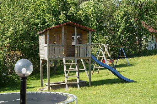 a playground with a tree house and a slide at Ferienwohnungen Paukner in Sankt Englmar