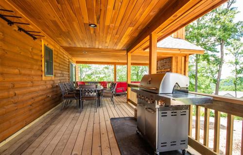 una terraza de madera con fogones y mesa en CJs Mountain Lodge, en McHenry