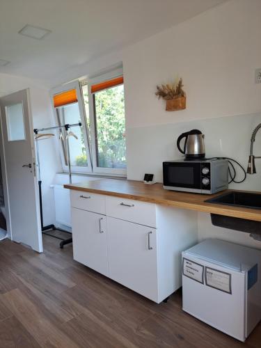 eine Küche mit weißen Schränken und einer Arbeitsplatte in der Unterkunft Maly domek in Szczecinek
