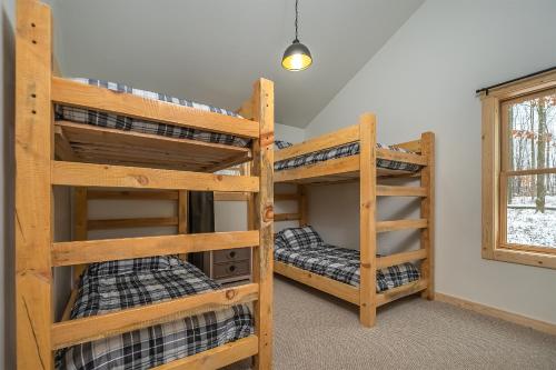 two bunk beds in a room with a window at Almost Eden in McHenry