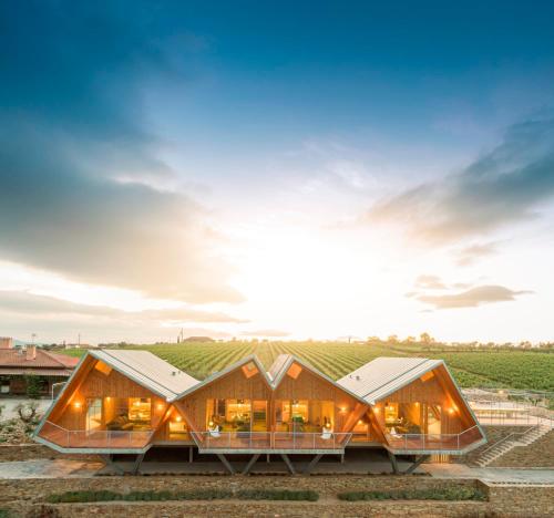 a house in a vineyard with the sun in the sky at QUINTA DA FAÍSCA - Agro Turismo in Favaios