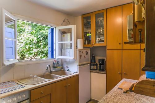 eine Küche mit Holzschränken, einem Waschbecken und einem Fenster in der Unterkunft Phlea Farm Studios in Alinda