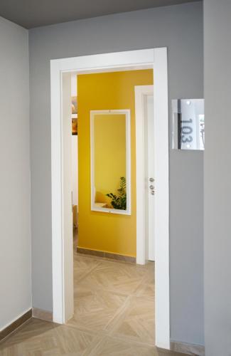 a hallway with a yellow wall and a mirror at Hotel Luris in Golem