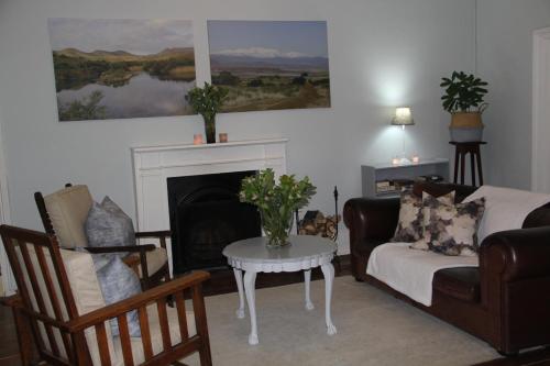 a living room with a couch and a fireplace at @karoo Guesthouse in Graaff-Reinet