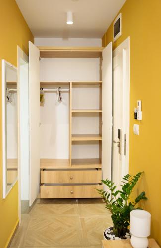 a bathroom with a closet with yellow walls and a plant at Hotel Luris in Golem