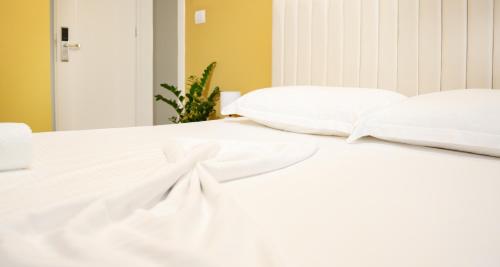 a bed with white sheets and pillows on it at Hotel Luris in Golem