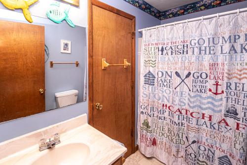 un bagno con lavandino e tenda da doccia di Home Sweet Cabin a Oakland