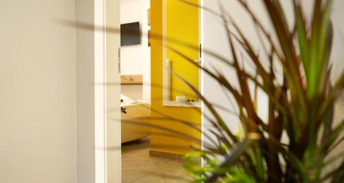 a bathroom with a yellow door and a plant at Hotel Luris in Golem
