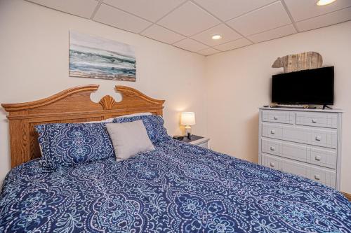 Schlafzimmer mit einem blauen Bett und einem TV in der Unterkunft Laurel Ridge in McHenry